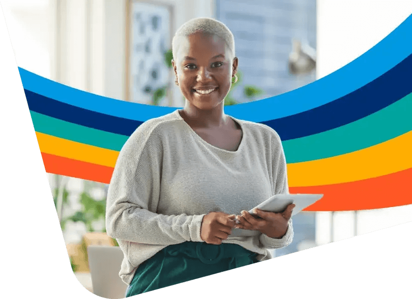 a woman is smiling while holding a tablet in front of a rainbow background .