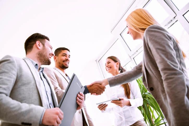 Smiling businesspeople shaking hands.