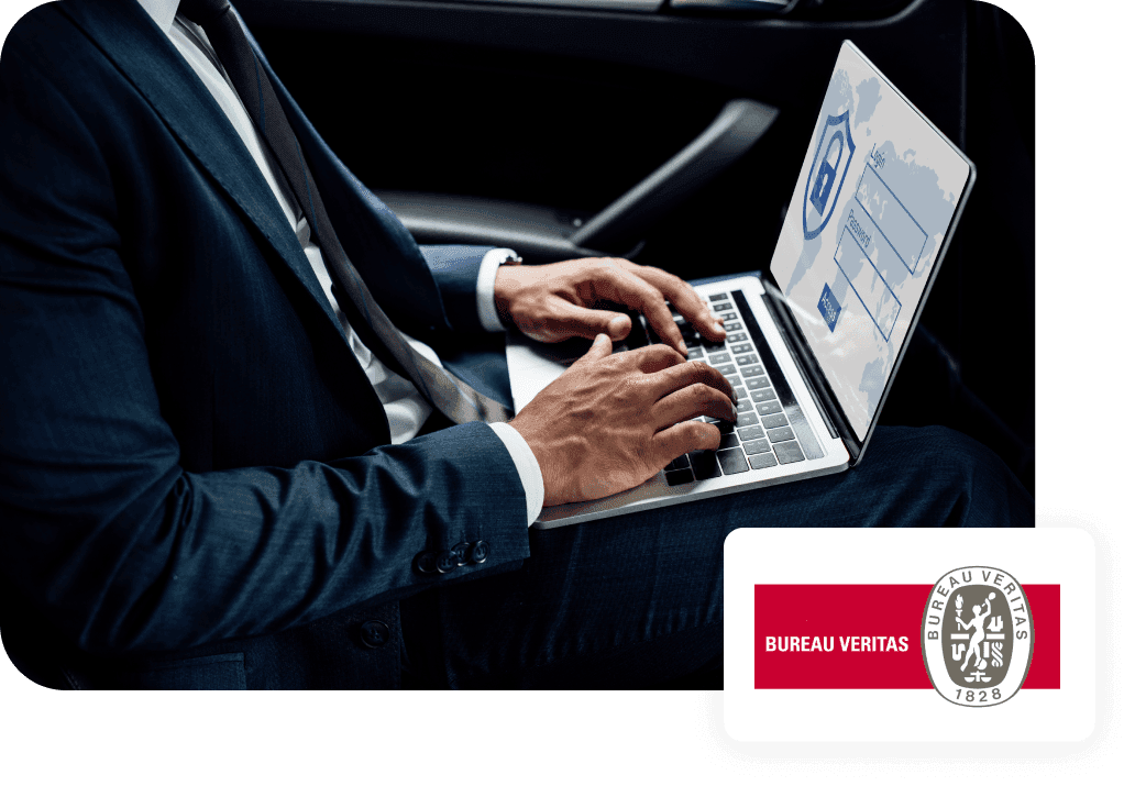 a man in a suit is typing on a laptop next to a sign that says bureau veritas