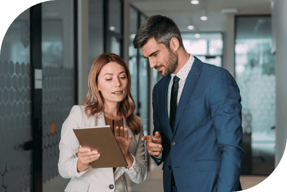 Two business professionals viewing a tablet in an office.