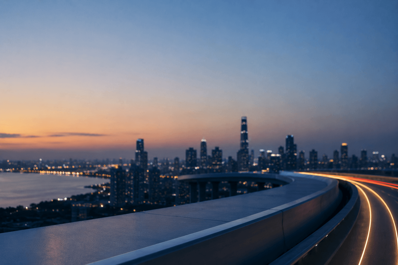 Curved highway with light trails overlooking a city skyline and bay at dusk.