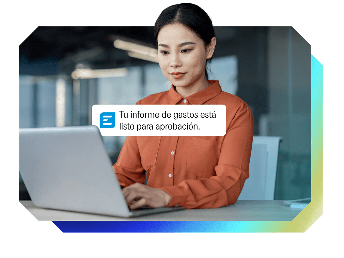 Woman working on a laptop receives an expense report approval notification.