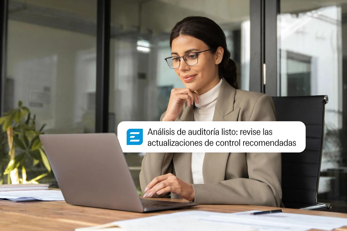 Woman working on a laptop receives an expense report approval notification.
