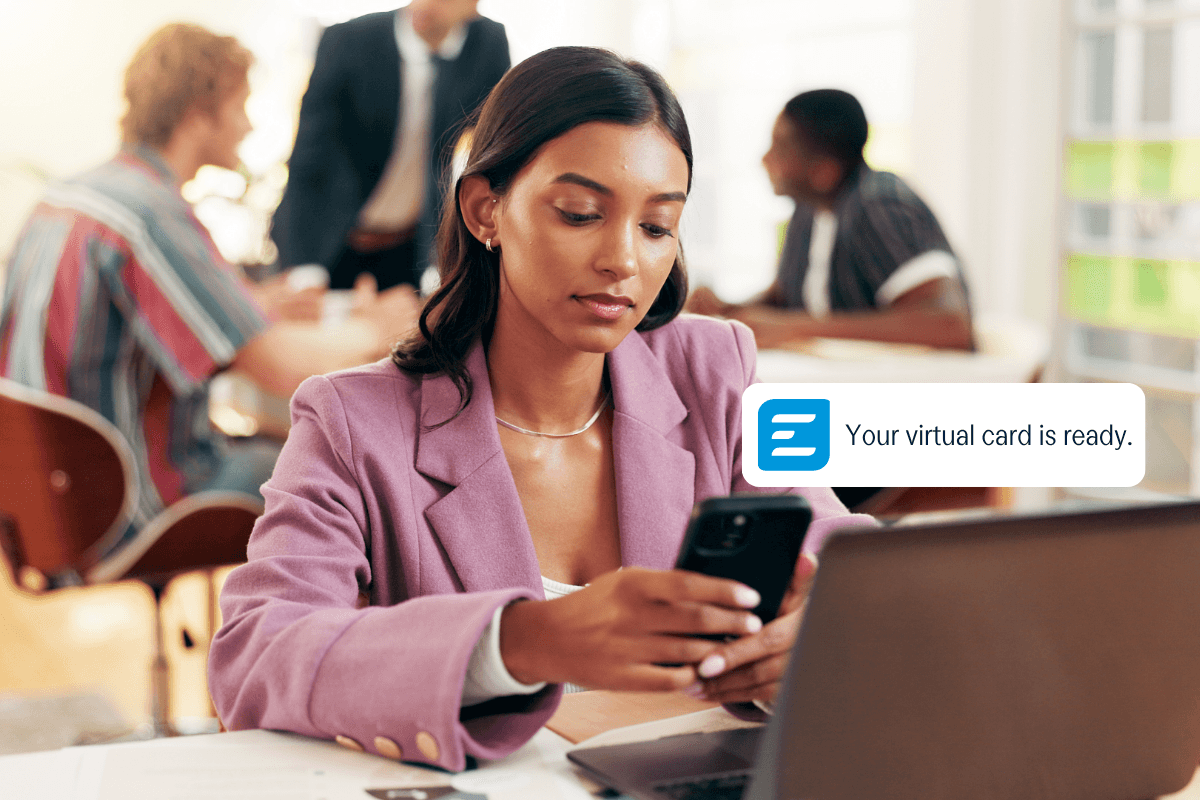 A woman looks at her phone, which displays a notification: "Your virtual card is ready."