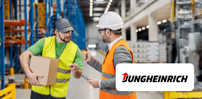 A worker with a box talks to a supervisor giving a thumbs up in a warehouse, with the Jungheinrich logo.