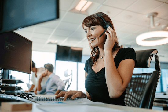 a woman wearing a headset is sitting in front of a computer