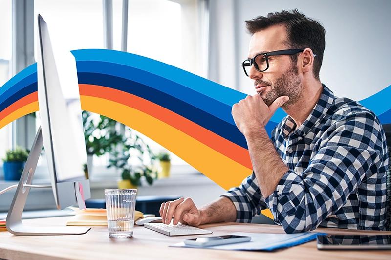 a man is sitting at a desk in front of a computer .