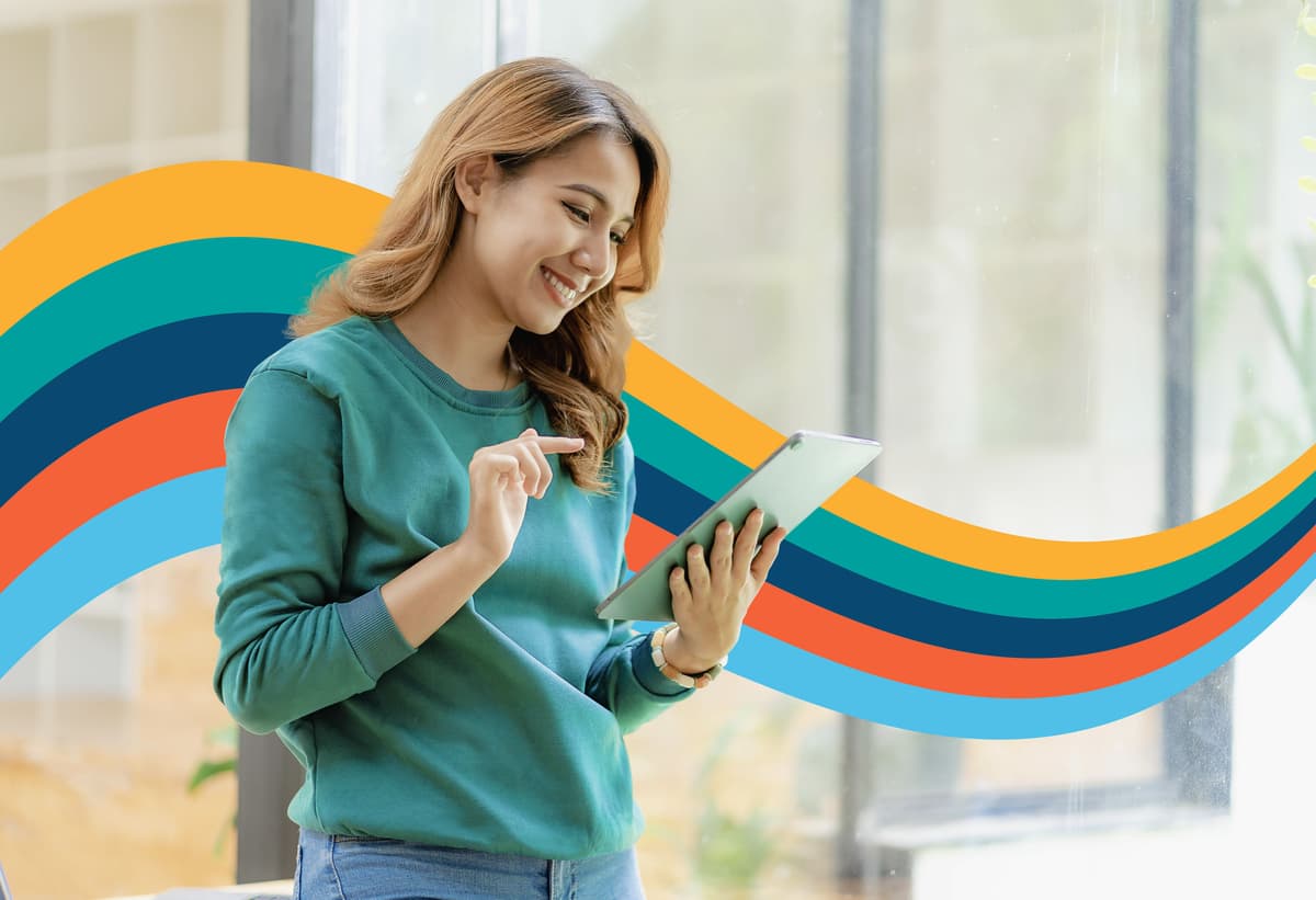 a woman is smiling while using a tablet computer .