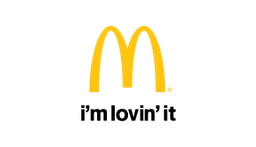 a yellow and green mcdonald 's logo with mountains in the background