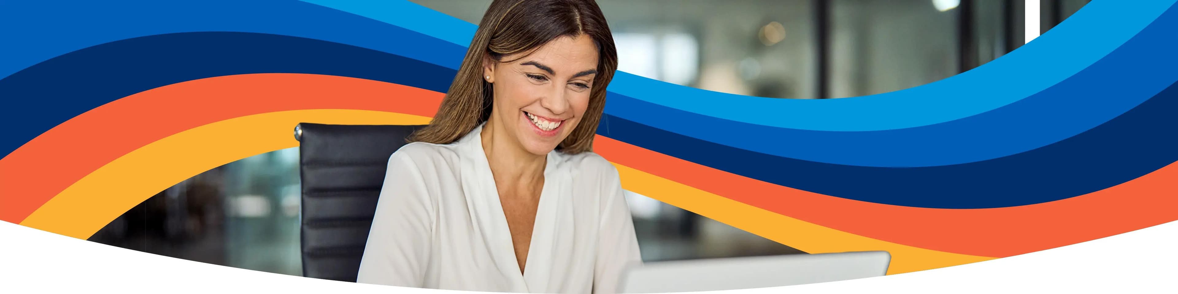 una mujer está sentada en un escritorio utilizando una computadora portátil.