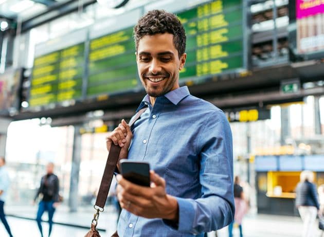 Happy business traveler checking Emburse Go