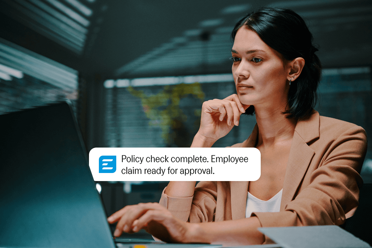 A woman works on a laptop, viewing a notification that reads: "Policy check complete. Employee claim ready for approval."