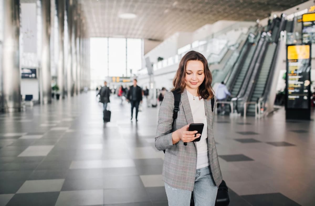 Woman looking at phone at the airport