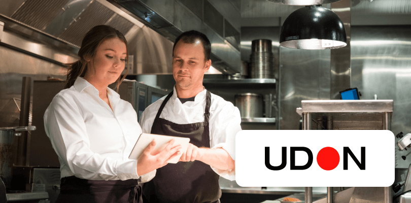 A man and two women smiling while collaborating in an office.