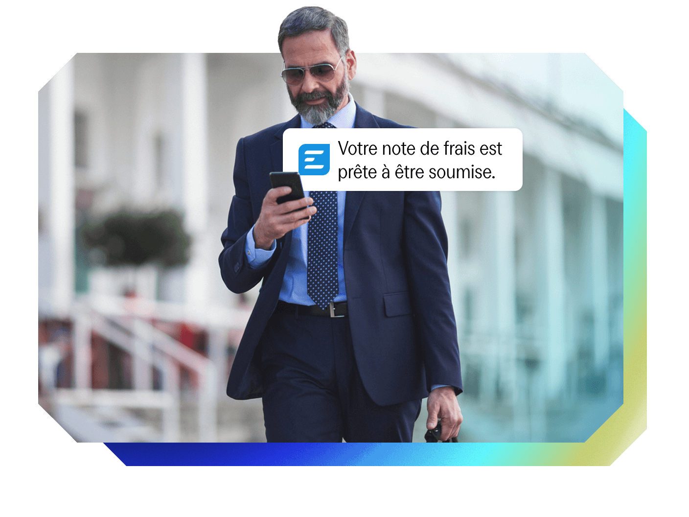 A man in a suit looks at his phone, which displays a notification: "Your expense report is ready to be submitted."