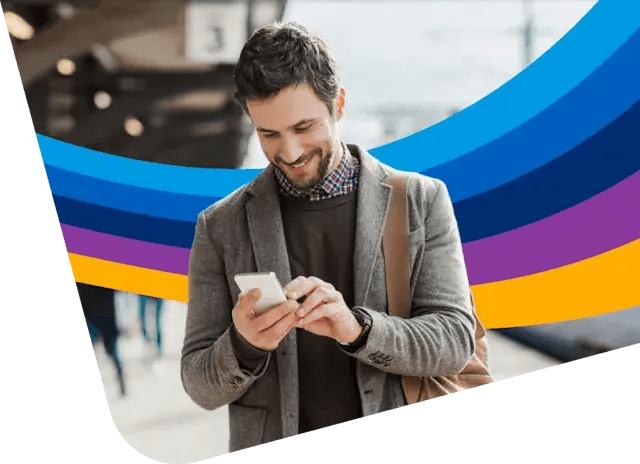a man is smiling while looking at his cell phone