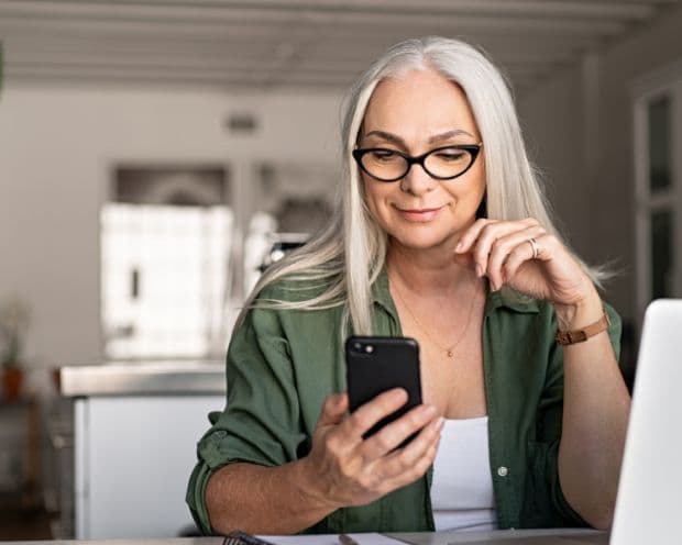 Person on phone using Emburse Tallie for expense reporting