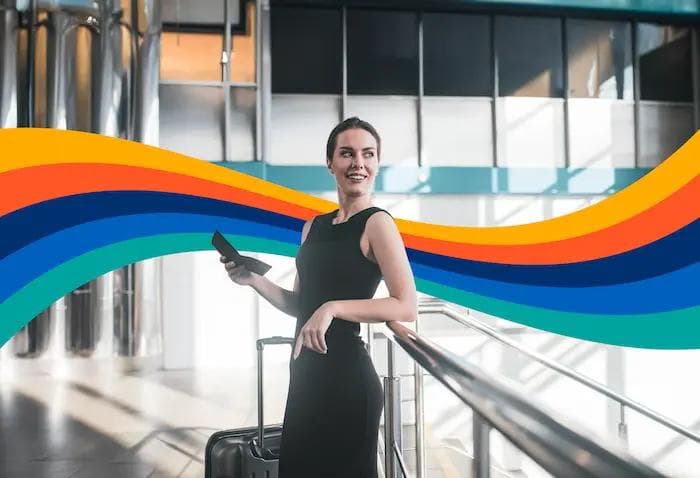 a woman in a black dress is standing in an airport with a suitcase .