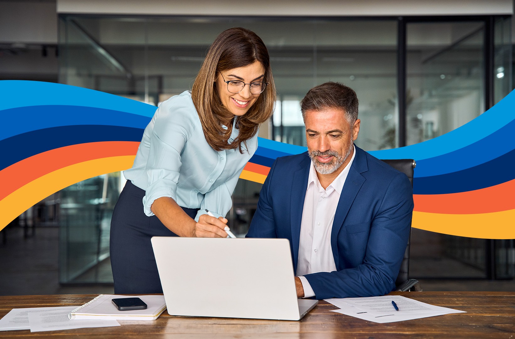 Two businesspeople looking at a laptop in an office